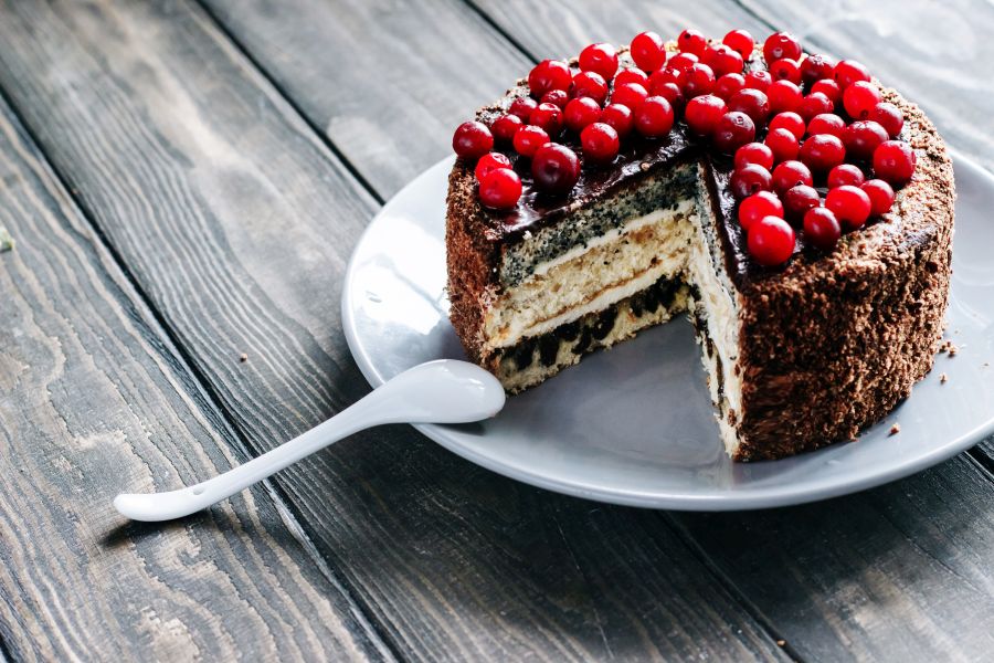Schokoladen-Mohn-Kuchen angeschnitten auf einem Holztisch